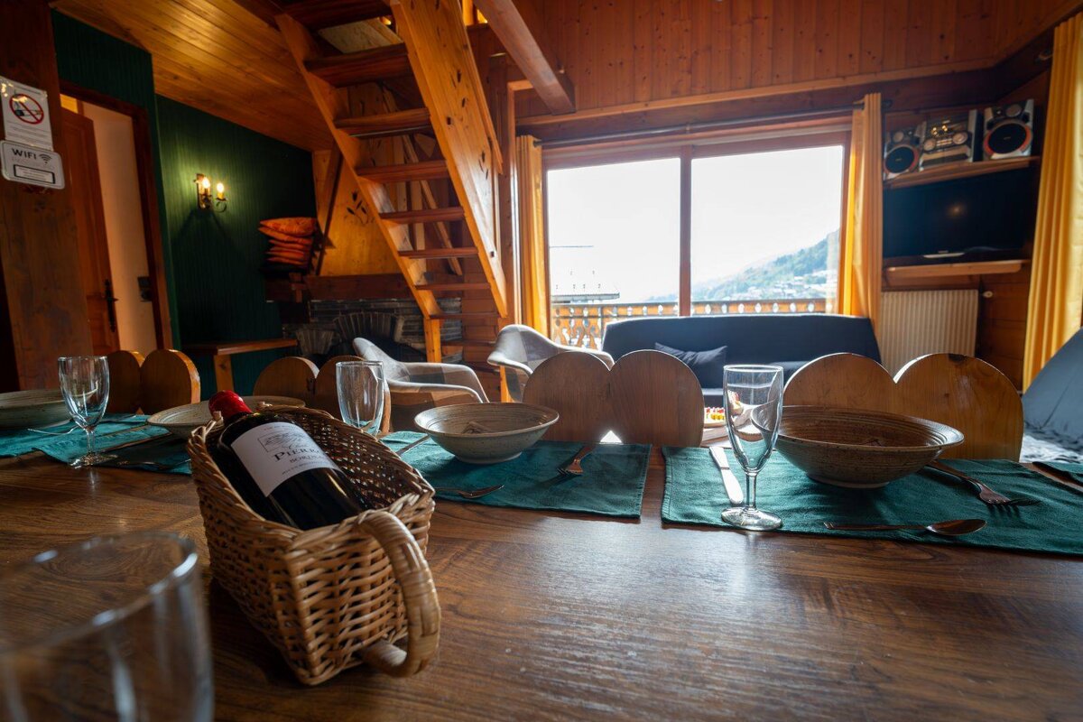 A bottle of pinot noir sits in a basket on a table