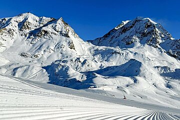 Snowy mountains and a groomed piste in Les Arcs early December 24