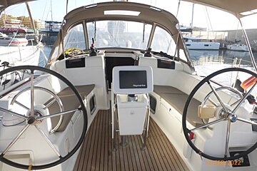 A raymarine monitor sits on the steering wheel of a boat