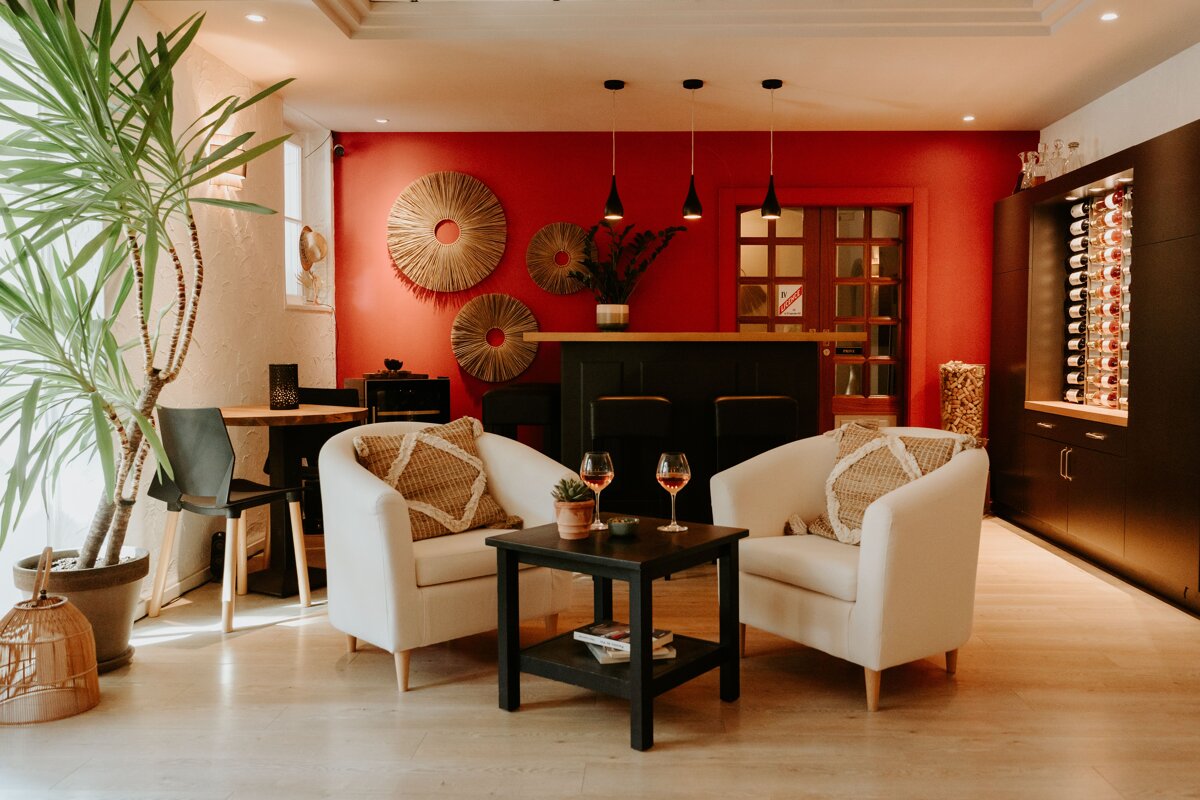 Two chairs and a table in a room with a red wall