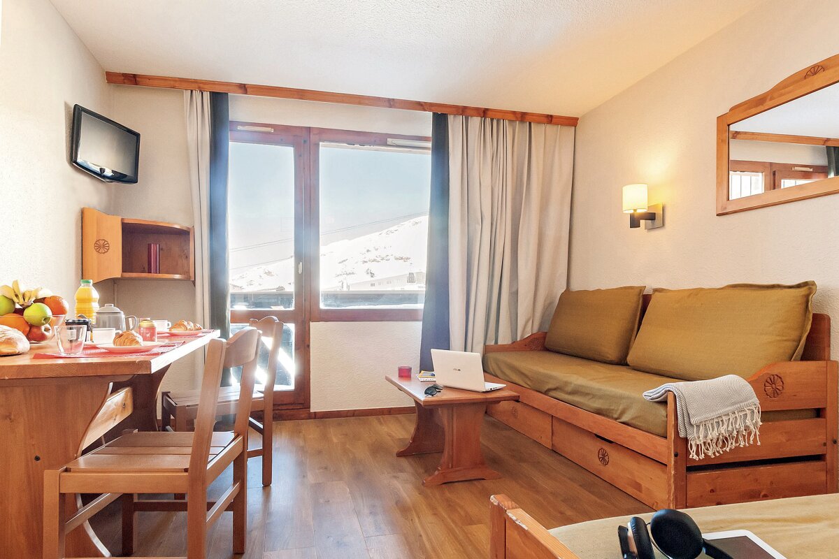 A living room with a couch and a table with a laptop on it