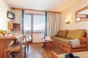 A living room with a couch and a table with a laptop on it