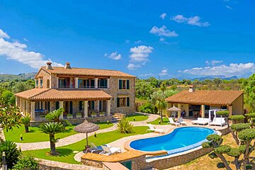 A large house with a large swimming pool in front of it