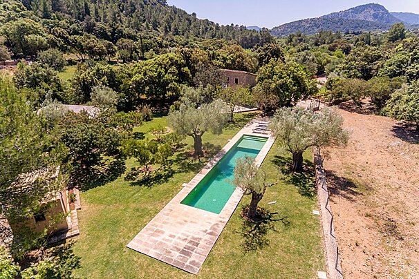 An aerial view of a large swimming pool surrounded by trees