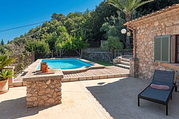 A stone house with a swimming pool in front of it