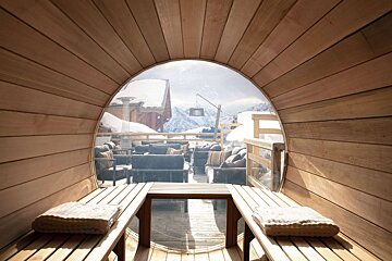 A wooden barrel with a view of snowy mountains