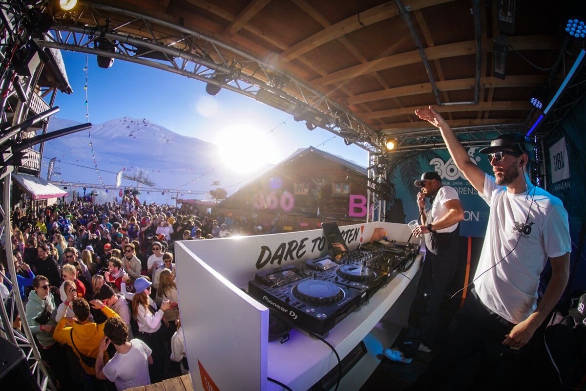 A man stands behind a dj booth that says dare to dream