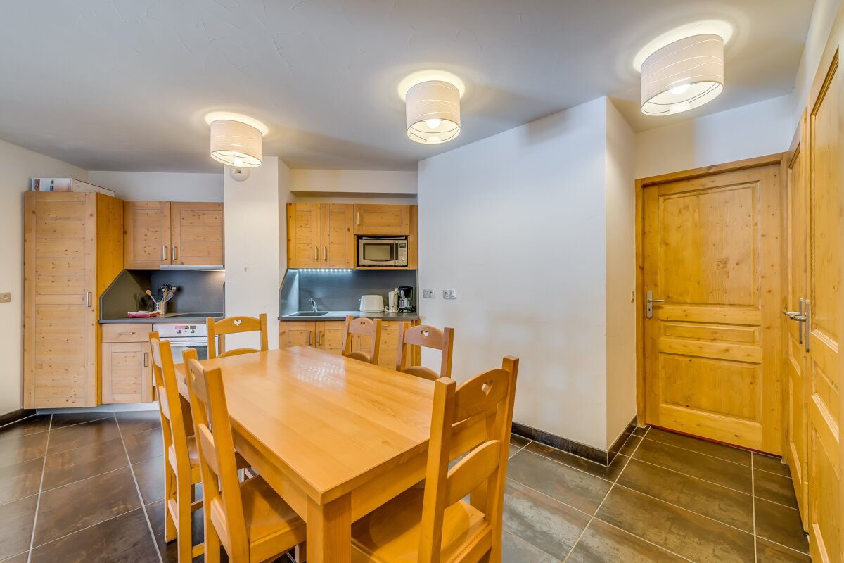 A kitchen with a table and chairs and a microwave