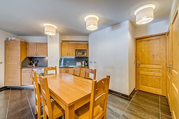 A kitchen with a table and chairs and a microwave