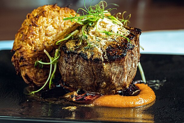 A close up of a steak on a black plate
