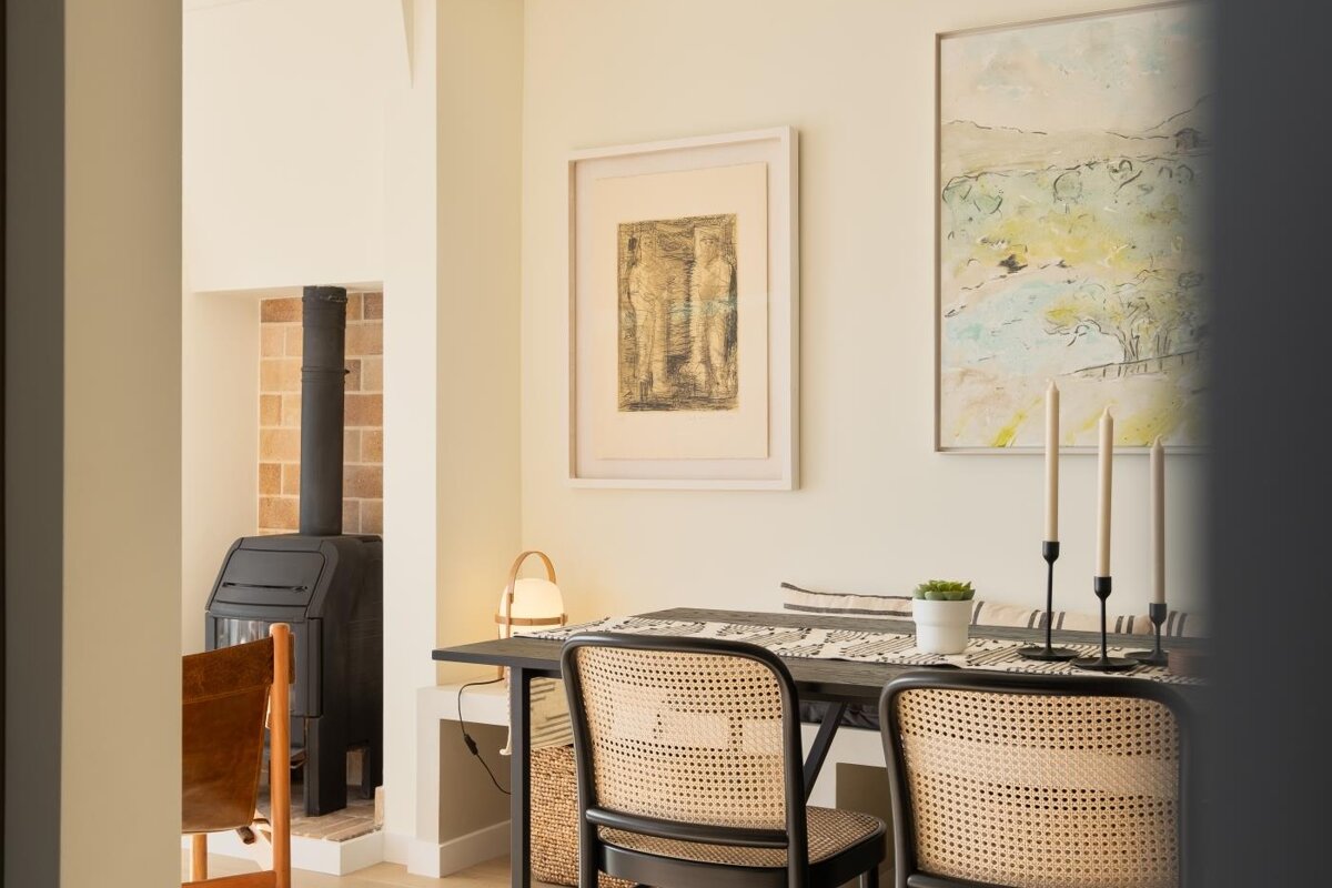 A room with a table and chairs and a painting on the wall