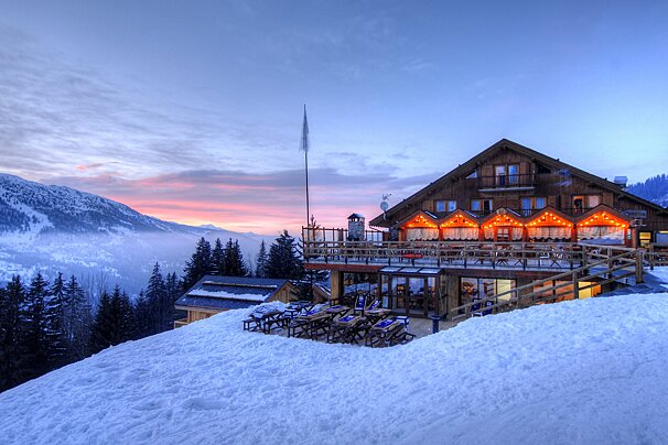 A snow covered building with a sunset in the background