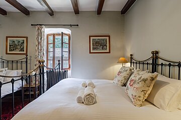 A bedroom with two beds and two pictures on the wall