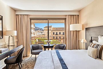 A hotel room with a large bed and a balcony