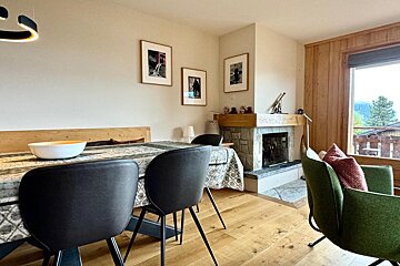 A dining room with a table and chairs and a fireplace