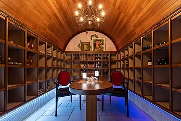 A wine cellar with a table and chairs and a chandelier