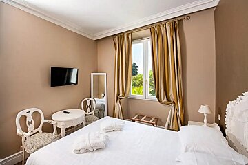A hotel room with a bed a table and a television