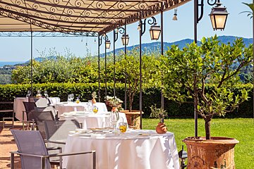 A restaurant with tables and chairs under an awning