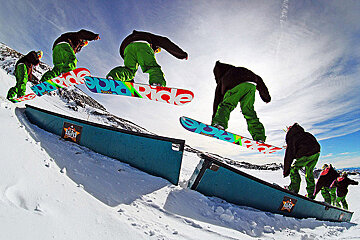 A snowboarder is doing a trick with the word ride on the board