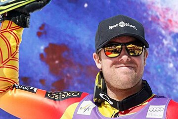 a ski racer holding his skis above his head