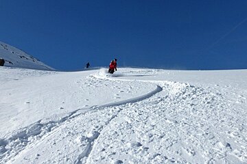 two skiers in snow with blue skies