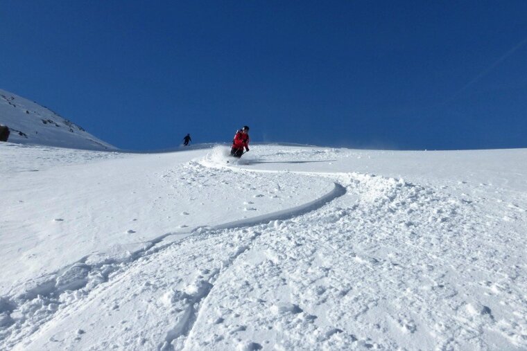 two skiers in snow with blue skies