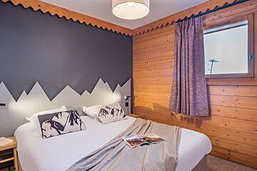 A bedroom with a bed and a magazine on it