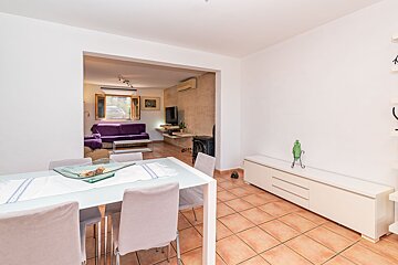 A living room with a table and chairs and a purple couch