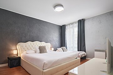 A bedroom with a large bed and a flat screen tv