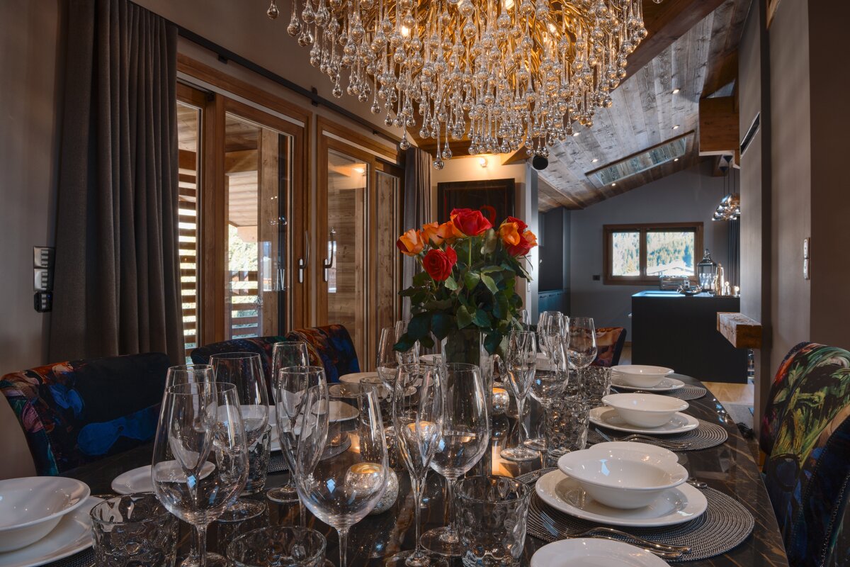 A dining room with a chandelier hanging from the ceiling