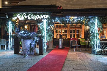 A restaurant with a red carpet and a sign that says capone