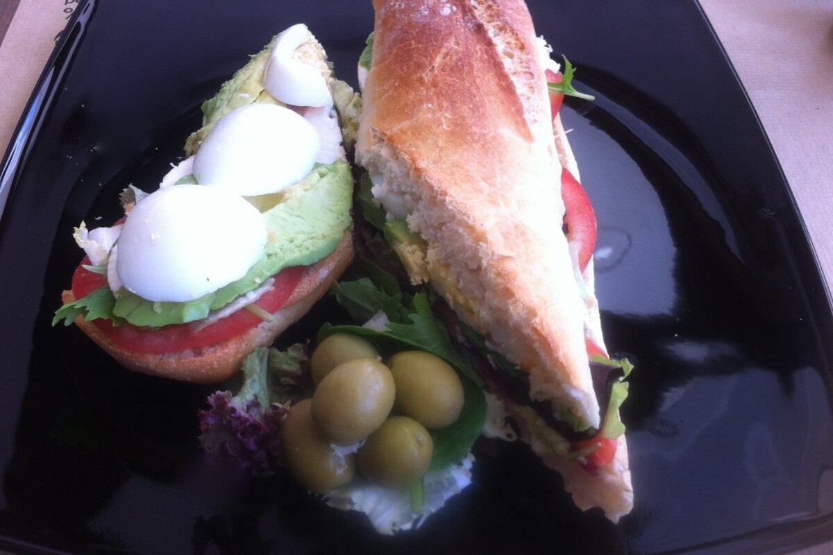 a black plate with tapas and olives