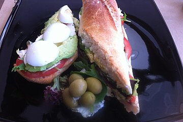 a black plate with tapas and olives