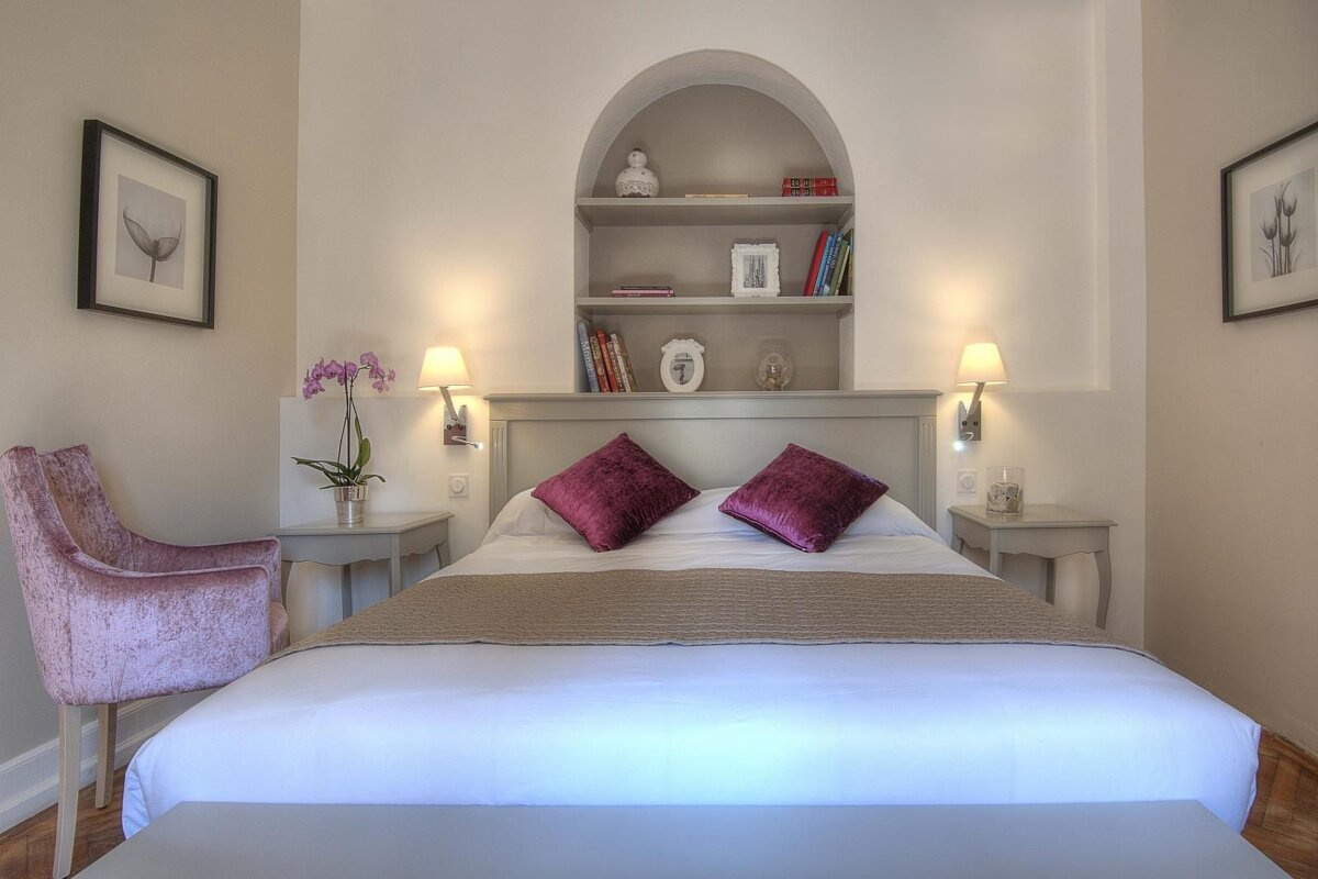 A small bedroom with a bed and a chair
