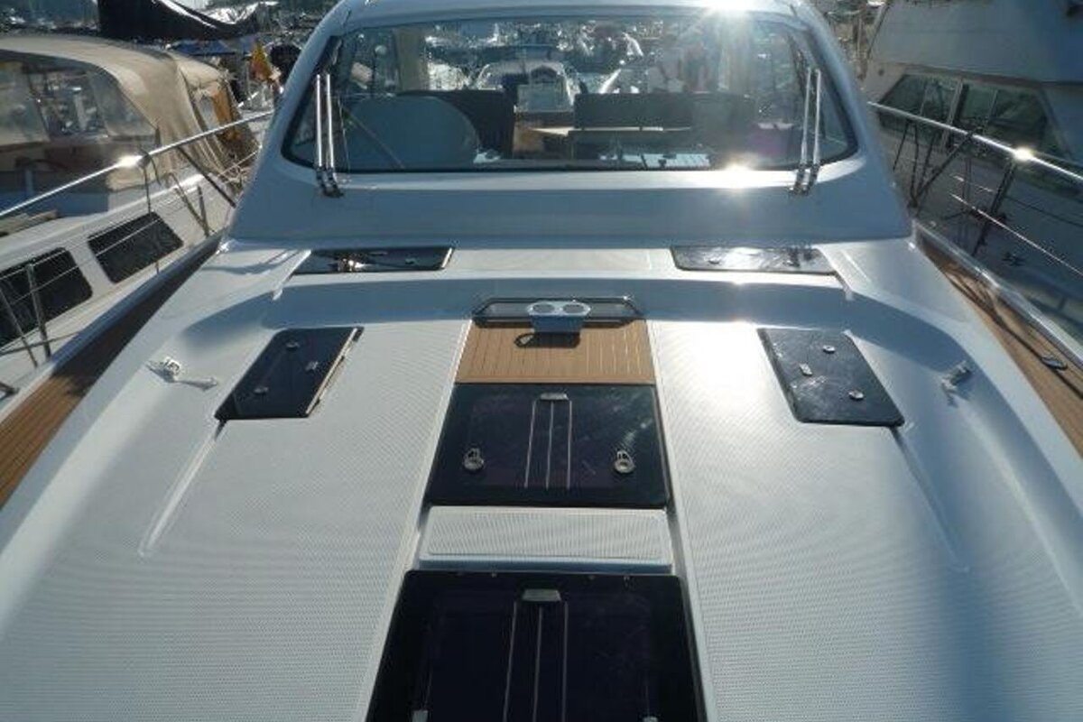 The front of a white boat with a wooden deck