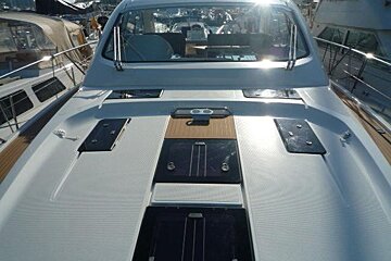 The front of a white boat with a wooden deck