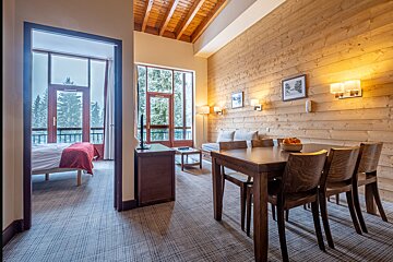 A hotel room with a dining table and chairs