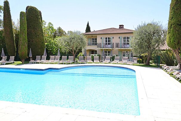 A large house with a swimming pool in front of it