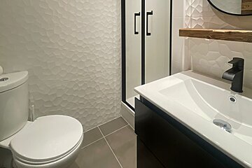 A bathroom with a toilet a sink and a shower