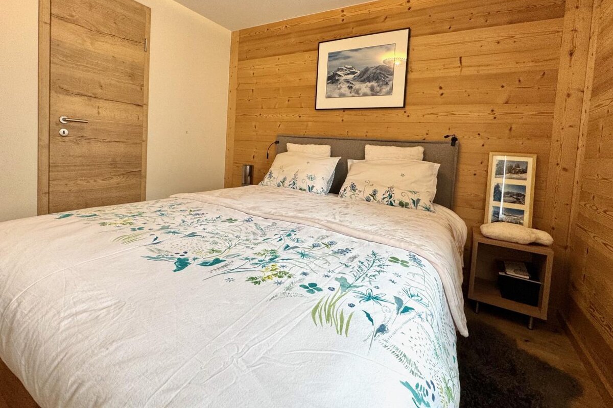 A bedroom with a bed and a picture on the wall