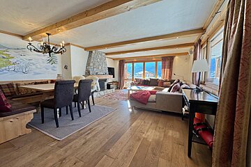 A living room with a couch a table and chairs