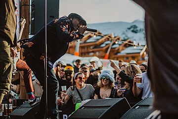 A man singing into a microphone in front of a crowd