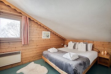 A bedroom with a king size bed and a window