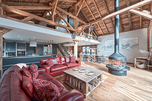 A living room with a red couch and a fireplace