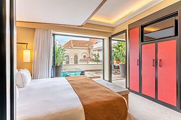 A hotel room with a large bed and a balcony