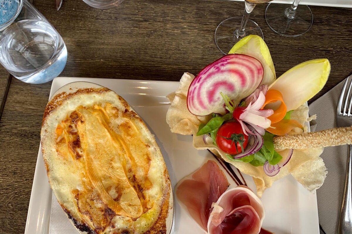 A white plate with a casserole and a salad on it