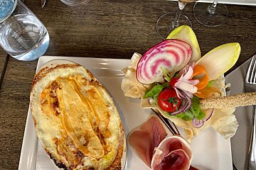 A white plate with a casserole and a salad on it