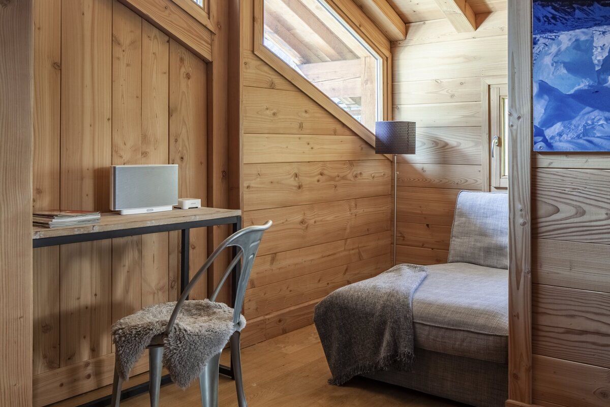 A wooden room with a chair and a desk