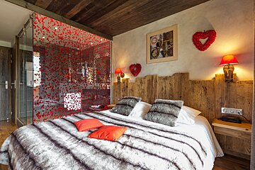 A bedroom with a bed and a heart on the wall