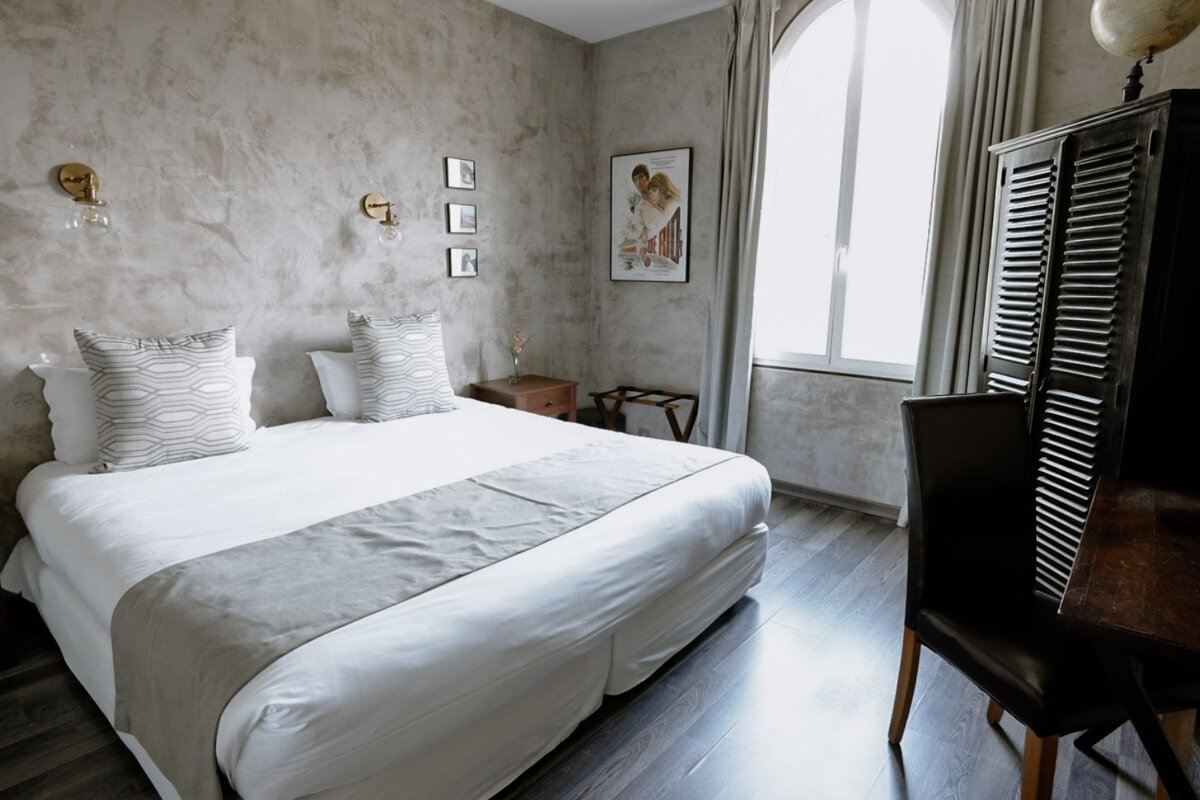 A hotel room with a bed and a chair